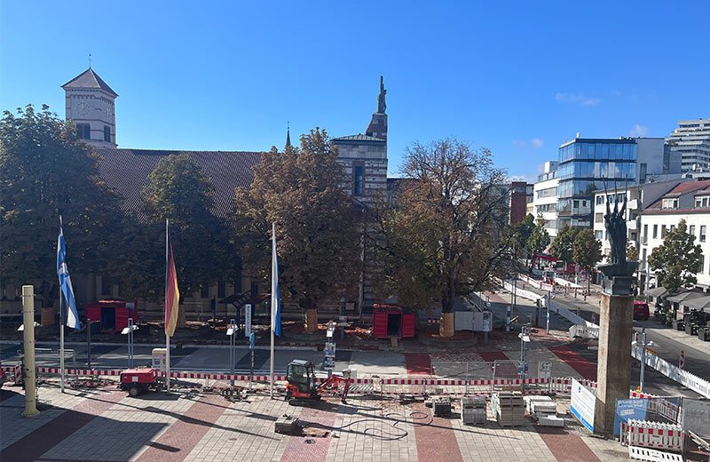 Blick von oben auf den Rathausplatz und die Ludwigstraße. Die farbigen Streifen auf der Ludwigstraße passen zu den Streifen auf dem Johannes- und dem Rathausplatz