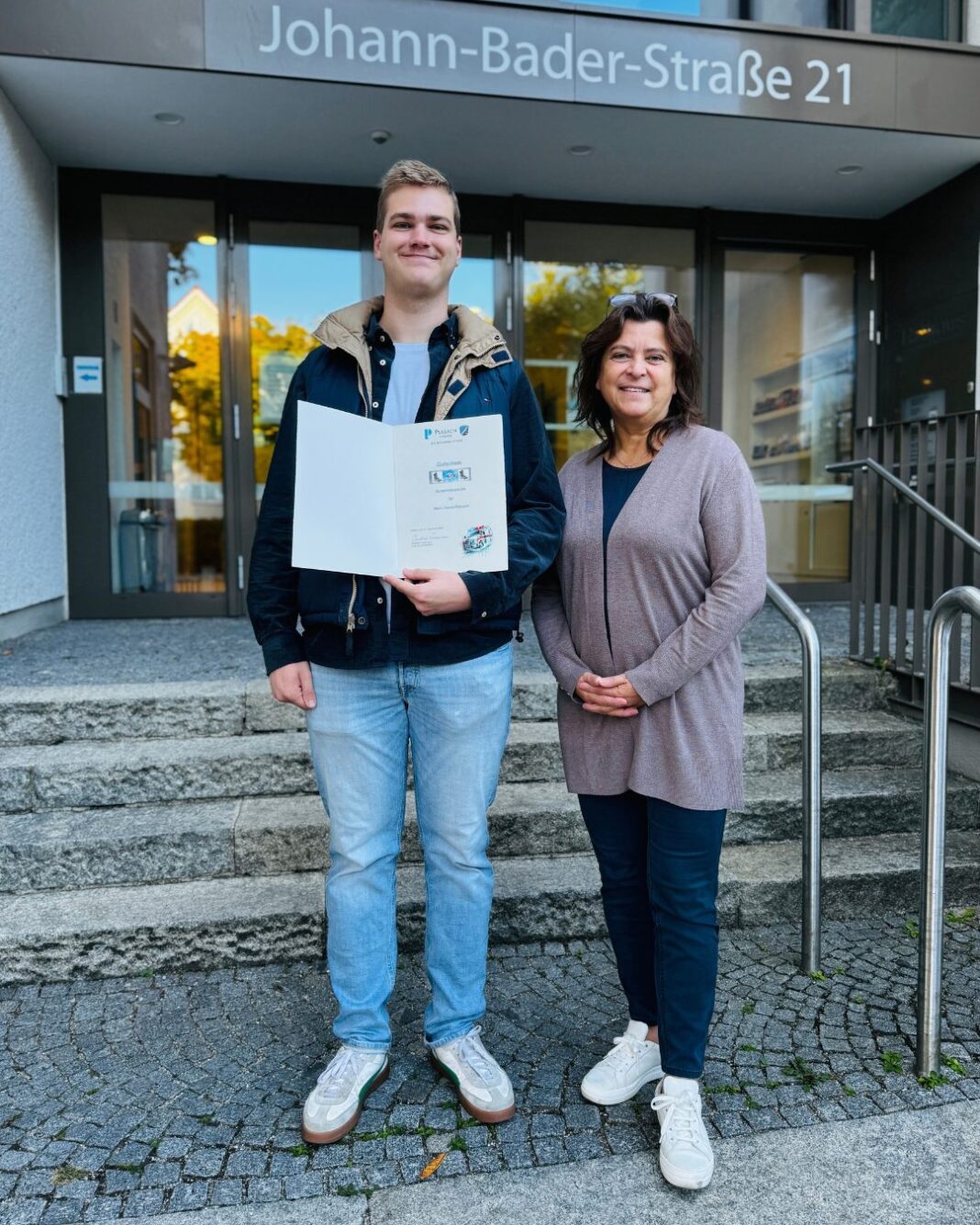 Unsere Erste Bürgermeisterin Christine Eisenmann gratuliert Daniel Riquarts zu seinem hervorragenden Abschluss als jüngster Notfallsanitäter Münchens und überreicht ihm einen Gutschein für ein Paar ho